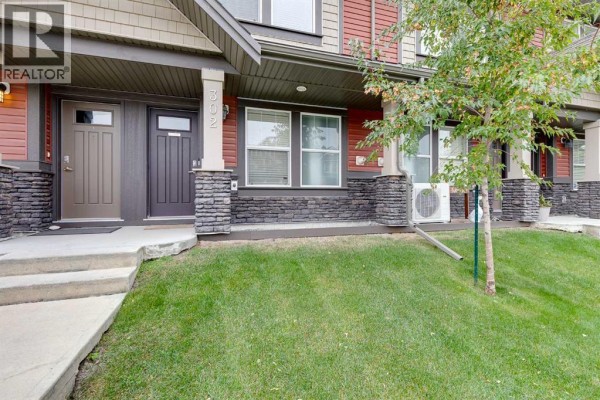 Close-up of townhouse entrances showing dark brown doors and stone accents. - 302, 280 Williamstown Close Nw, Airdrie