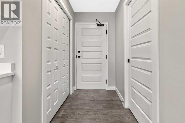 Entryway featuring a double closet, light gray walls, and a white door. - 302, 97 Station Drive, Sylvan Lake