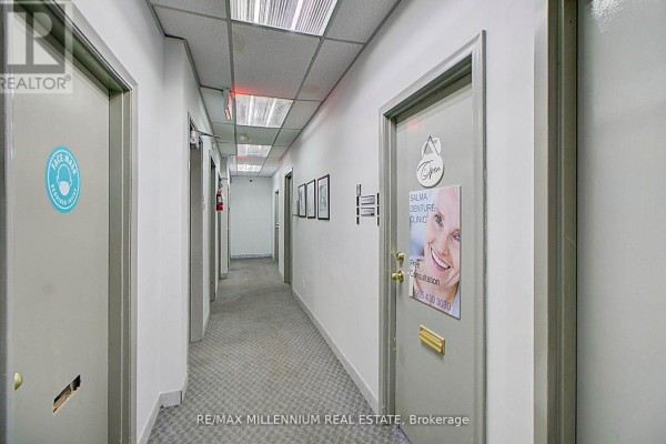 Another view of the interior office hallway showing doors with business names and signage. - 302 - 101 Dundas Street W, Whitby