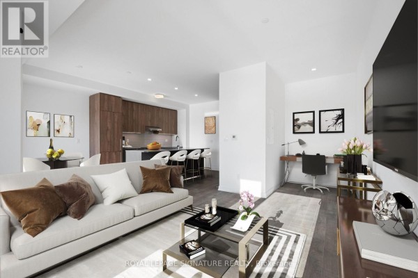 Living room with beige sofa, coffee table, and a desk area. - 302 - 11 Walder Lane, Richmond Hill
