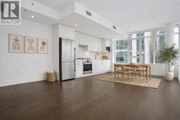 Modern kitchen with stainless steel appliances, white cabinetry, and herringbone backsplash. - 302 2455 Kingsway, Vancouver