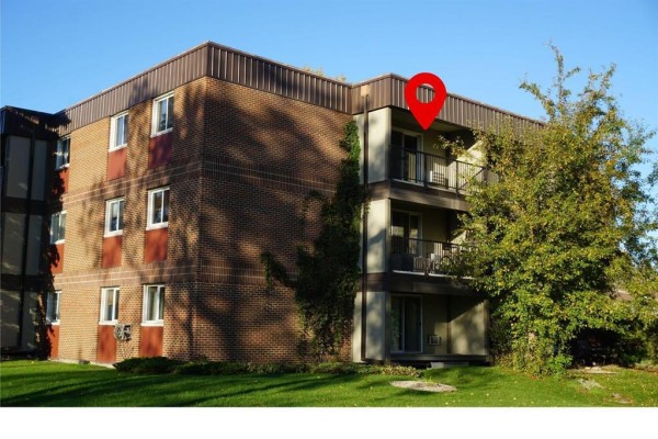 Aerial view of a brick apartment building with a flat roof and surrounding trees. - 302 470 Kenaston Boulevard, Winnipeg