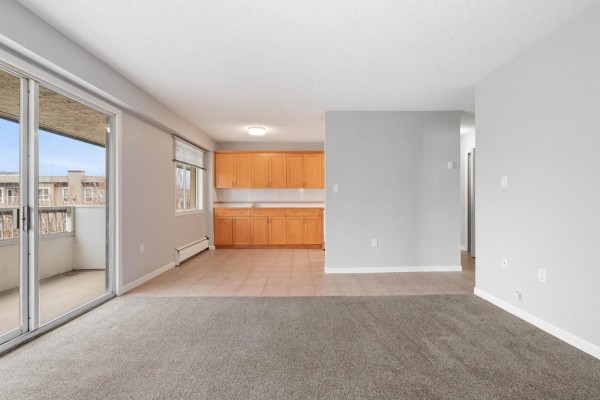 Open layout with kitchen cabinetry, tile flooring, and sliding glass door - 302 9477 Cook Street, Chilliwack Proper West, Chilliwack
