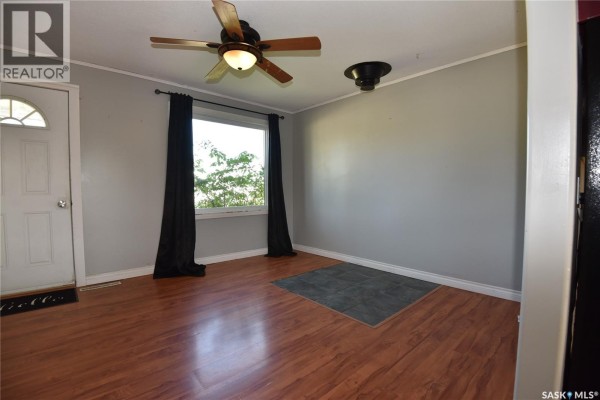 Living room with wood laminate flooring, gray walls, and black curtains. - 302 Centre Street, Codette