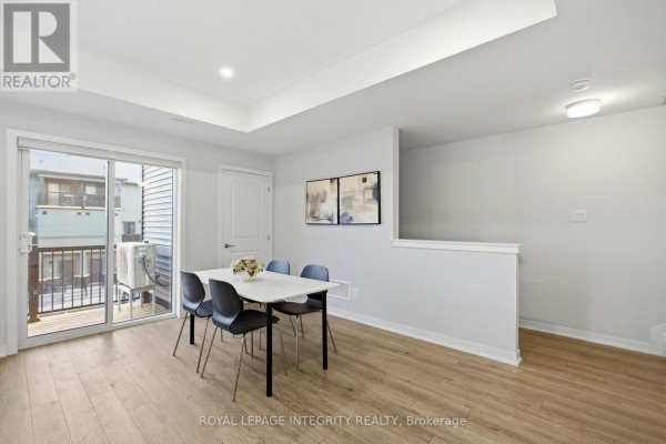 Laundry room with stacked white washer and dryer next to a closed door. - 302 Parnian Private, Ottawa