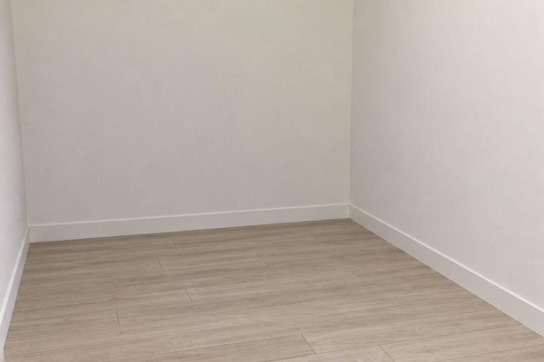 Empty room with white walls, light wood floors, and white baseboards. - 3020 - 2031 Kennedy Road, Toronto