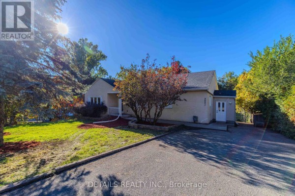 Aerial view of the property showing the driveway, lawn, and surrounding trees. - 3021 Richmond Road, Ottawa