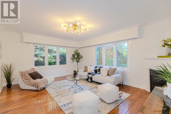 Living room with white sofa, patterned rug, coffee table, and hardwood floors. - 3021 Richmond Road, Ottawa