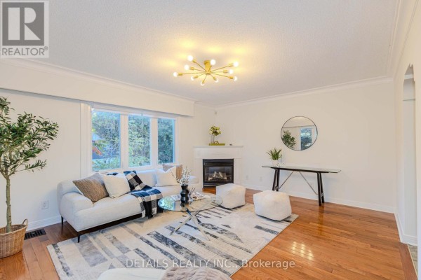 Living room with fireplace, seating area, large windows, and hardwood flooring. - 3021 Richmond Road, Ottawa