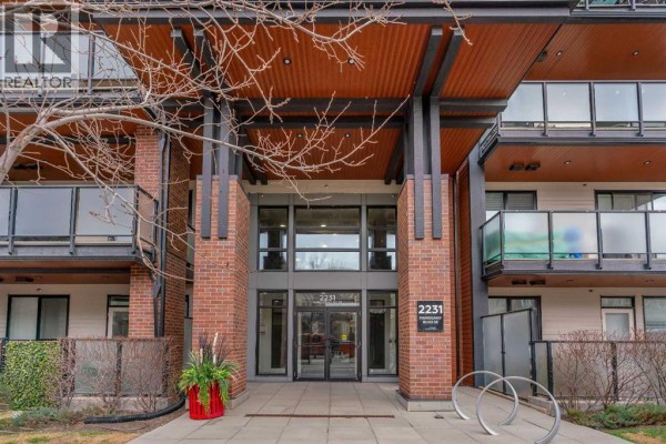 Apartment building lobby with leather seating, wood-paneled walls, mailboxes, and elevator access. - 303, 2231 Mahogany Boulevard Se, Calgary