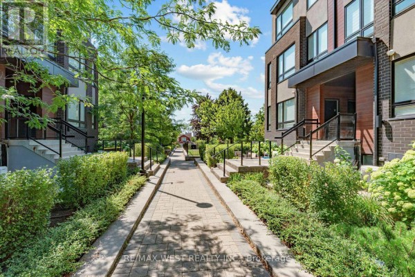 Pathway leading through landscaped grounds between townhouse units. - 303 - 1150 Briar Hill Avenue, Toronto