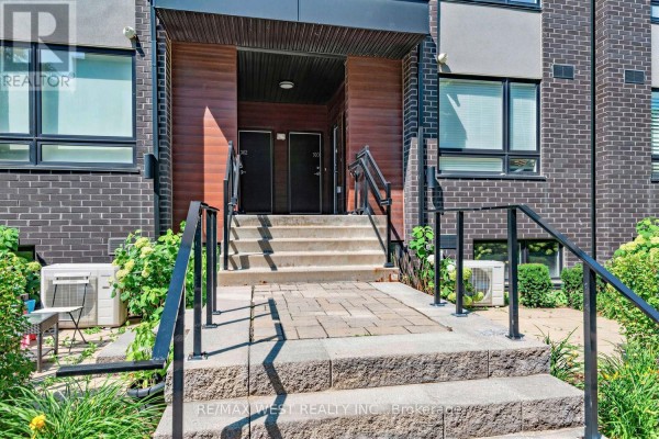 Front entrance with stone steps, black railings, and double doors. - 303 - 1150 Briar Hill Avenue, Toronto