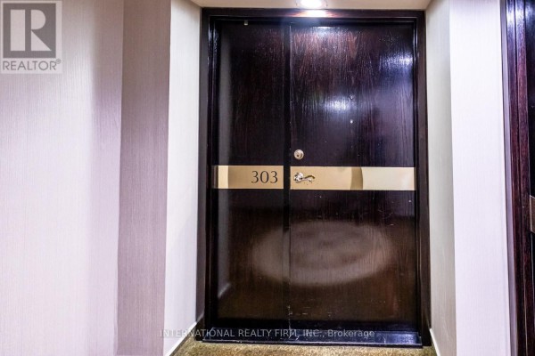 Dark wood double doors with brass hardware and a "303" number plaque. - 303 - 1700 The Collegeway, Mississauga