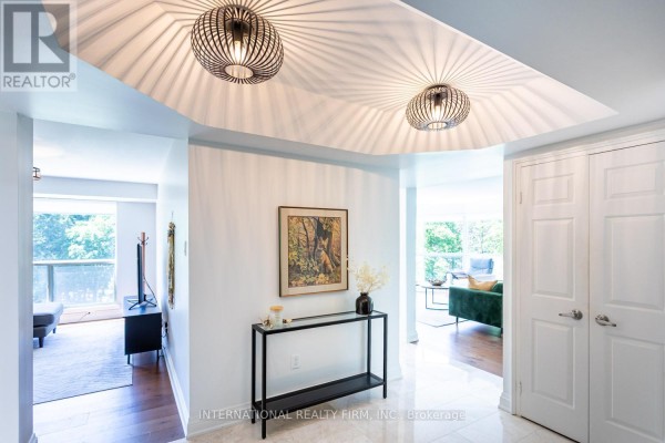 Interior foyer with marble floors, white walls, and modern light fixtures. - 303 - 1700 The Collegeway, Mississauga