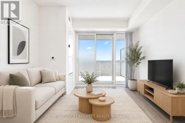Living room with a sectional sofa, coffee tables, and a balcony door. - 303 - 195 Commerce Street, Vaughan