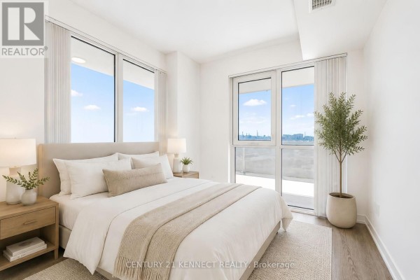Bedroom with a queen-sized bed, light wood flooring, and large windows overlooking the city. - 303 - 195 Commerce Street, Vaughan
