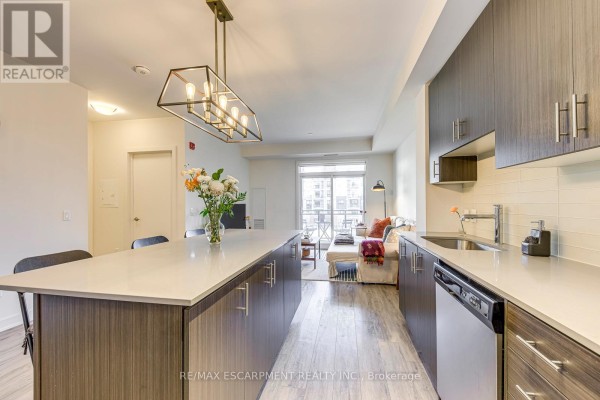 Modern kitchen with large island and island light fixture - 303 - 320 Plains Road E Burlington