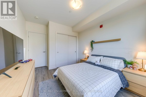 Bedroom with bed, nightstands, lamps, TV, dresser - 303 - 320 Plains Road E Burlington