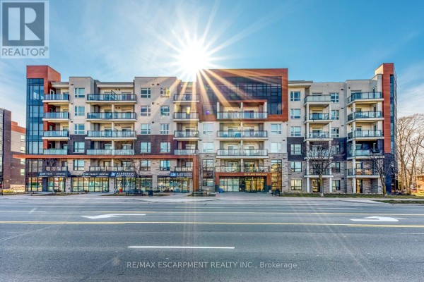 Modern condo building with balconies and storefronts - 320 Plains Road East Burlington