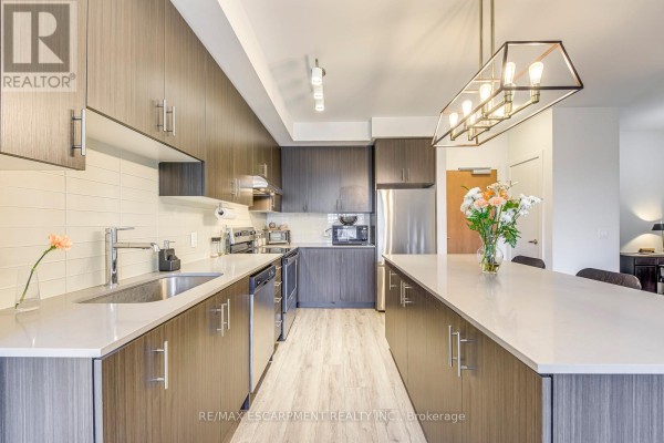 Modern kitchen with island, quartz countertops, stainless steel appliances - 303 - 320 Plains Road E Burlington