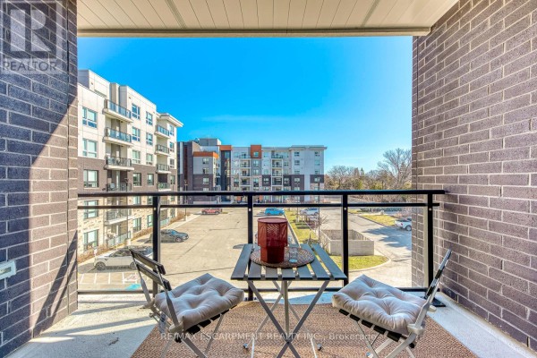 Balcony with chairs and table - 303 - 320 Plains Road E Burlington