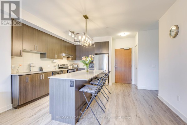 Modern kitchen with island and stainless steel appliances - 303 - 320 Plains Road E Burlington