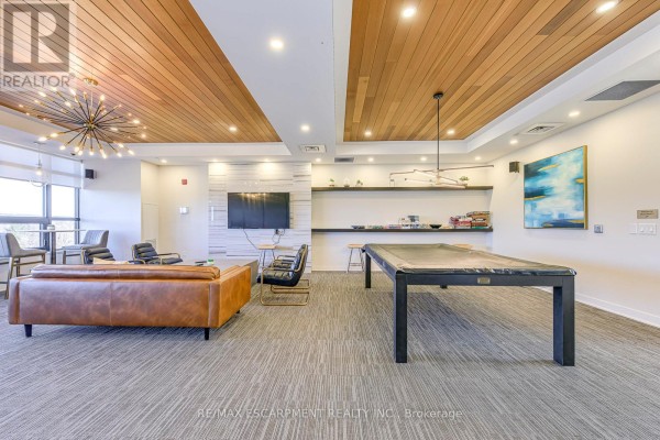 Pool table and leather sofa in a modern living room with wood ceiling - 303 - 320 Plains Road E Burlington