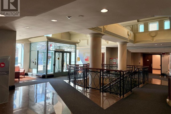 Interior lobby of the apartment building with glass elevator doors and marbled floors. - 303 - 39 Pemberton Avenue, Toronto