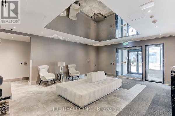 Apartment building lobby with cream sectional sofa, white armchairs, and mirrored ceiling panels. - 303 - 398 Highway 7 Street E, Richmond Hill