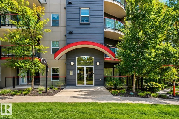 Close-up of the apartment building entrance with glass doors and red trim. - #303 10611 117 St Nw, Edmonton