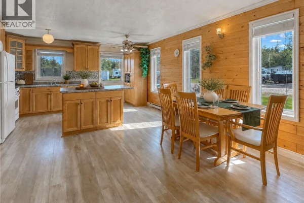 Kitchen with oak cabinets, white appliances, granite countertops, and a large island. - 303 Corrigal Crescent, Turtle View