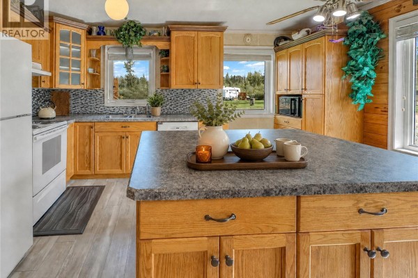 Dining area with a wooden table, chairs, and wood paneled walls. - 303 Corrigal Crescent, Turtle View