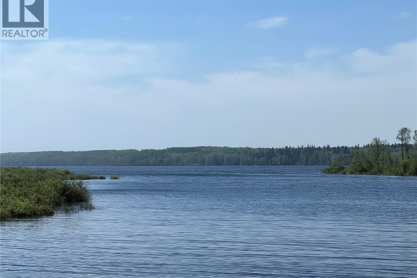 Wide view of Green Lake with trees on the horizon under a blue sky. - 303 Main Street, Green Lake