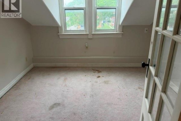 Attic room with dormer windows and carpet - 303 Wellington Street West Chatham