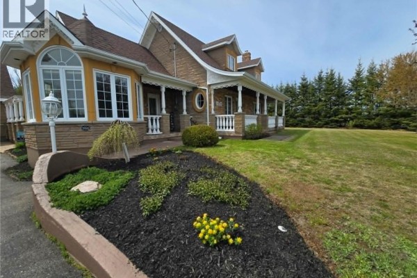 Exterior view of a large house with a three-car garage, lawn, and stone statue. - 3033 St Laurent, Saint Laurent