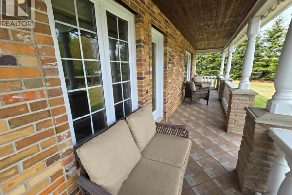 Living room with tiled floors, large windows, leather sofa, armchairs, and coffee table. - 3033 St Laurent, Saint Laurent