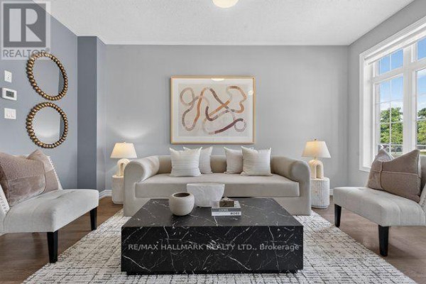 Living room with gray walls, a beige sofa, two accent chairs, and a black marble coffee table. - 3034 Eighth Line, Oakville