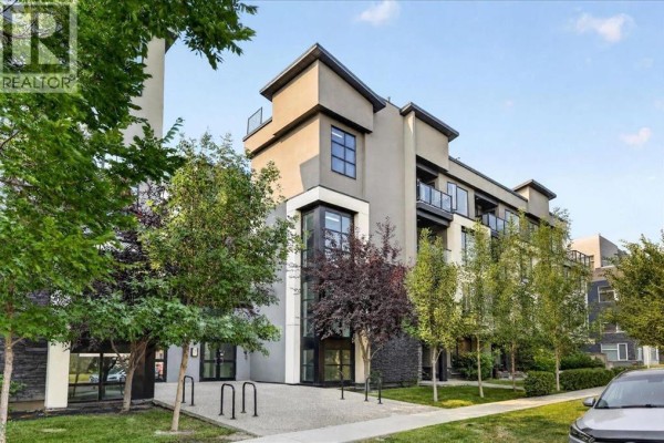 Front exterior of an apartment building with trees and landscaping, featuring dark and light facade colors. - 304, 607 17 Avenue Nw, Calgary
