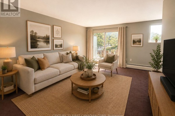 Living room with sliding glass doors to a balcony, couch, armchair, and TV unit. - 304 - 1830 Dumont Street, London East