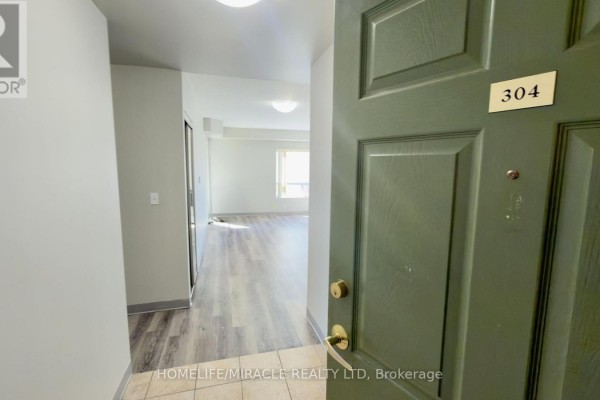 View from inside the apartment, showing the open front door and hallway leading to the living area. - 304 - 237 Auburn Drive, Waterloo