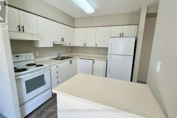 Kitchen with white cabinets, white countertops, a white stove, and a white refrigerator. - 304 - 237 Auburn Drive, Waterloo