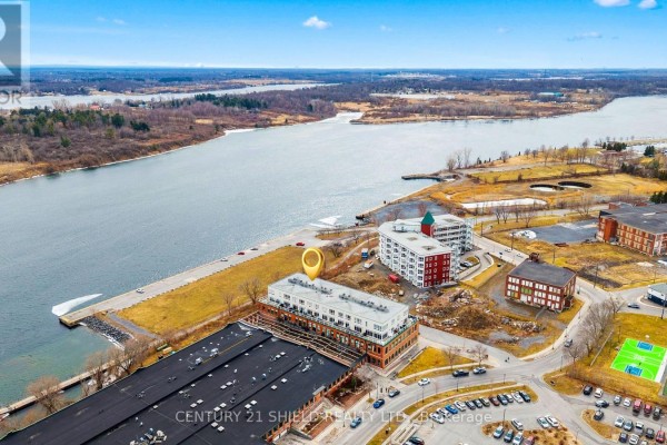 Aerial drone shot of a waterfront building complex with a river and surrounding industrial area. - 304 - 703 Cotton Mill Street, Cornwall