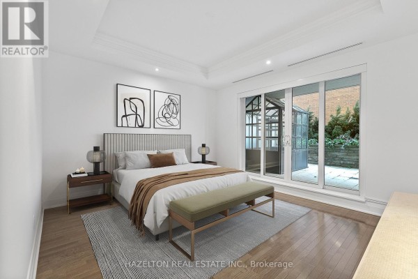 Bedroom with king-size bed, bench, and sliding glass doors leading to a patio. - 304 - 80 Yorkville Avenue, Toronto