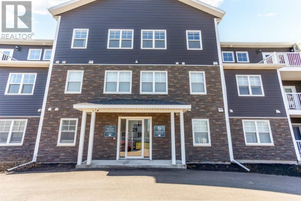 Front entrance of apartment building with dark siding and stone facade. - 304 29 Stratford Road, Stratford