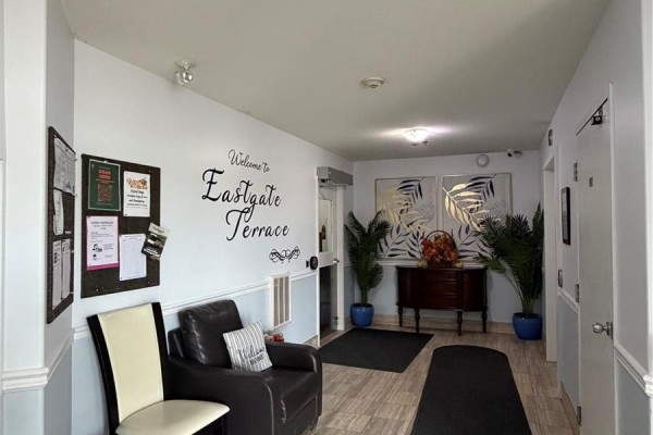 Lobby entrance of Eastgate Terrace with seating area and bulletin board. - 304 3730 Eastgate Drive E, Regina
