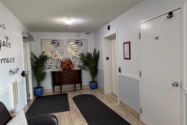 Eastgate Terrace lobby with elevator, artwork, and decorative plants. - 304 3730 Eastgate Drive E, Regina
