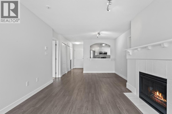 Balcony with a white railing overlooking a street and bare trees. - 304 5500 Lynas Lane, Richmond