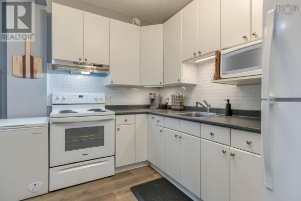 Apartment entryway with two white doors, a map on the wall, and light grey walls. - 304 6369 Coburg Road, South End