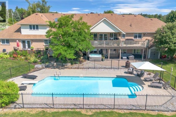Rear exterior view of the property with a large swimming pool, hot tub, patio, and multi-level decking. - 304 German School Road, Paris