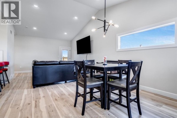 Interior view of a dining area with a dark wood table, chairs, and light wood floors. - 304 Horizon Lane, Chatham